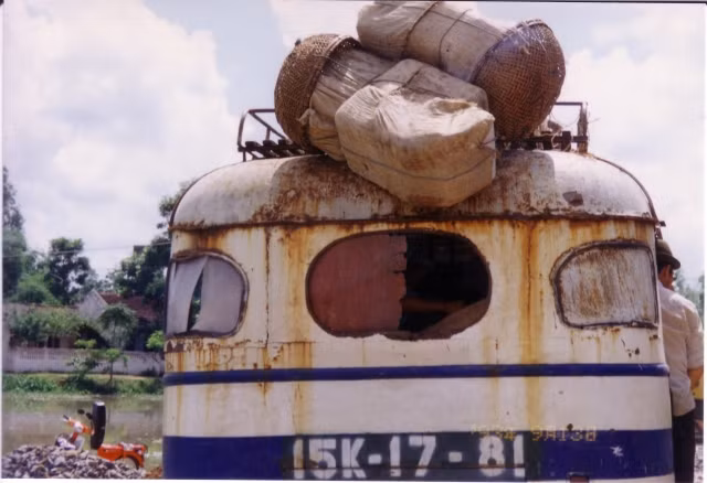 Chiếc xe buýt cũ kỹ biển số Hải Phòng chạy trên quốc lộ.