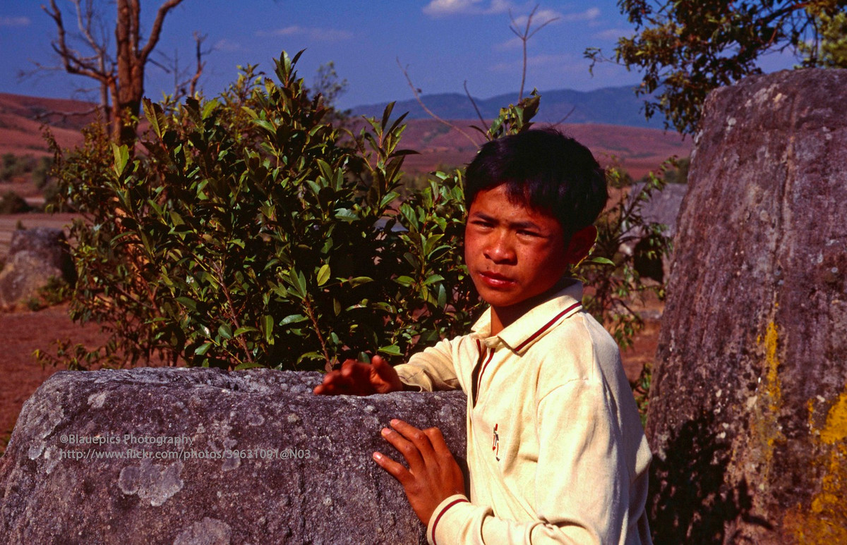 Thiếu niên địa phương bên chiếc chum đá cổ xưa.