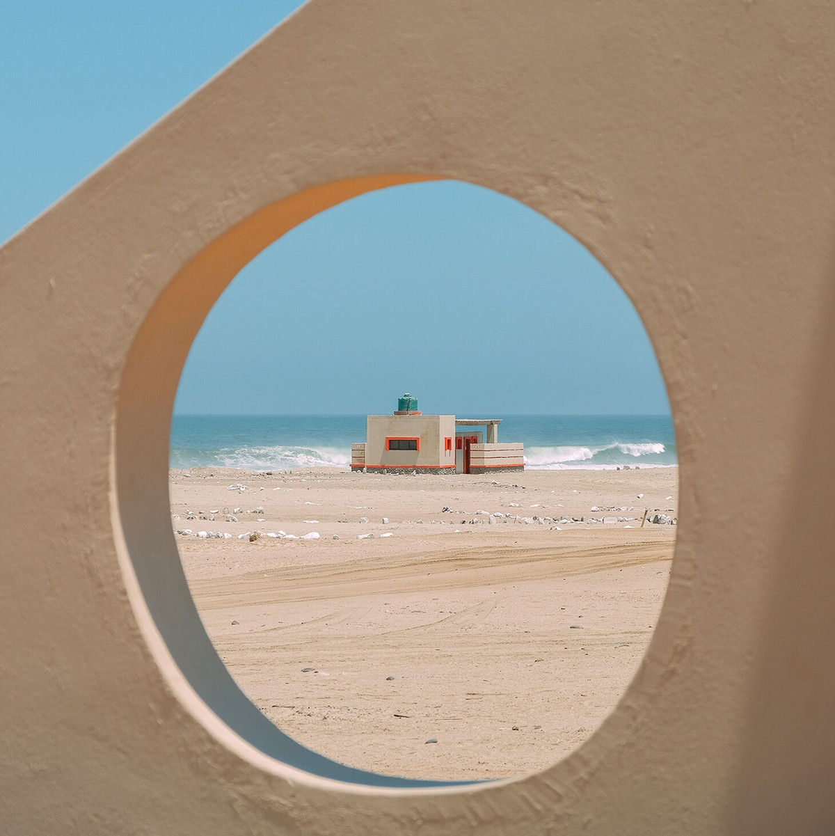 Trong ảnh, đường cao tốc C34, dọc theo bờ biển của Namibia, hầu như không thể phân biệt được với sa mạc xung quanh. Bên trái sa mạc. Bên phải đại dương. Ở giữa là một con đường đầy muối và cát nối chặt giữa hai phần. Dưới bầu trời u ám, ba bề mặt cát - biển - đường mờ dần thành một vệt màu nâu xám không thể phân biệt được.