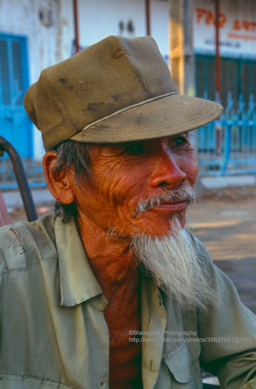 Cụ ông ngồi trên chiếc xe xích lô.