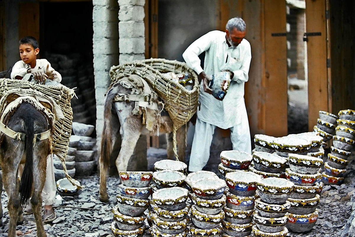 Cụ ông đưa những chiếc cối đá lên bao tải trên lưng con lừa. Chúng được dùng để xay các loại gia vị và nguyên liệu thực phẩm khác.