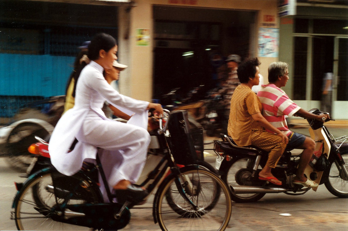 Nữ sinh áo dài đạp xe trên phố.