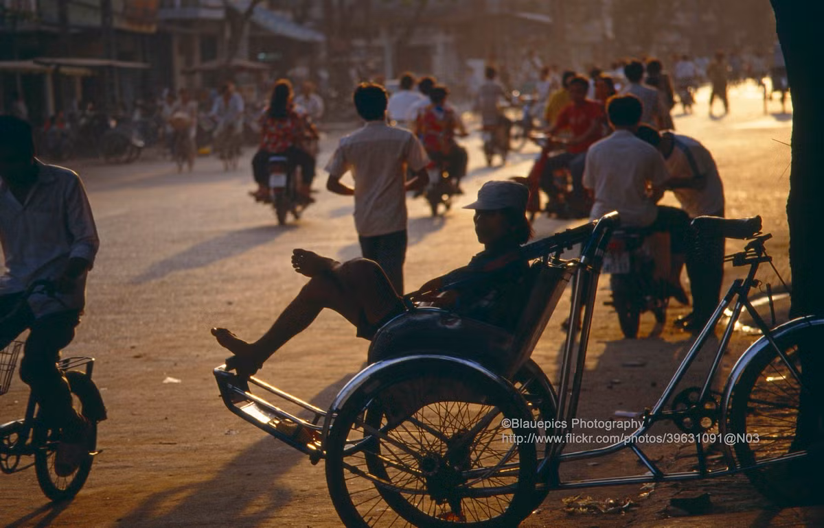 Người lái xích lô ngồi đợi khách trong ánh chiều tà.