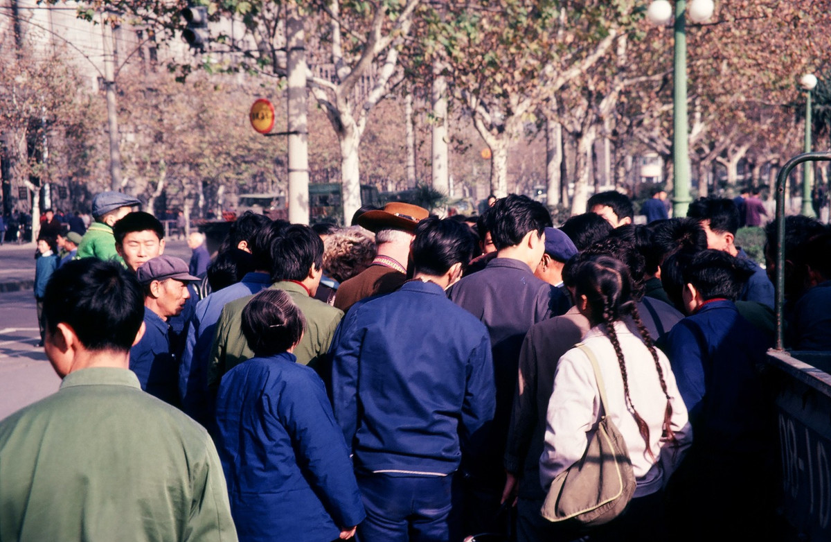 Cặp vợ chồng người phương Tây hòa lẫn vào dòng người trên đường phố Thượng Hải.