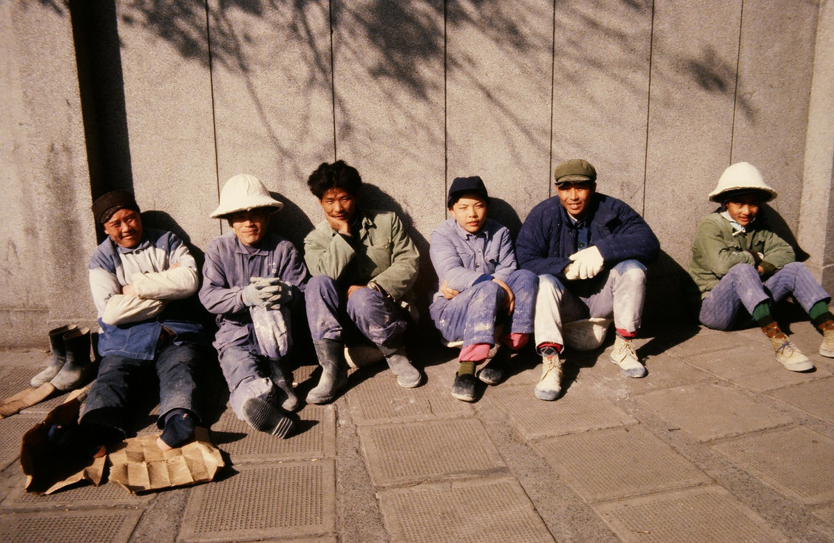 Nhóm công nhân sưởi nắng ở góc phố vào giờ nghỉ.