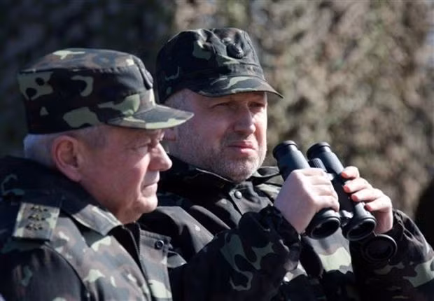 Chủ tịch Rađa Tối cao Oleksandr Turchynov (phải) và Bộ trưởng quốc phòng Igor Tenyukh quan sát buổi tập trận của quân đội Ukraine gần Chernigiv (phía bắc Ukraine).