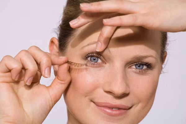 Gắn mi giả sau khi trang điểm. Trước khi gắn mi giả, bạn nên trang điểm hoàn thiện hầu hết các phần trên gương mặt. Nếu không, bạn sẽ rất khó khăn trong việc bôi màu mắt sau đó.