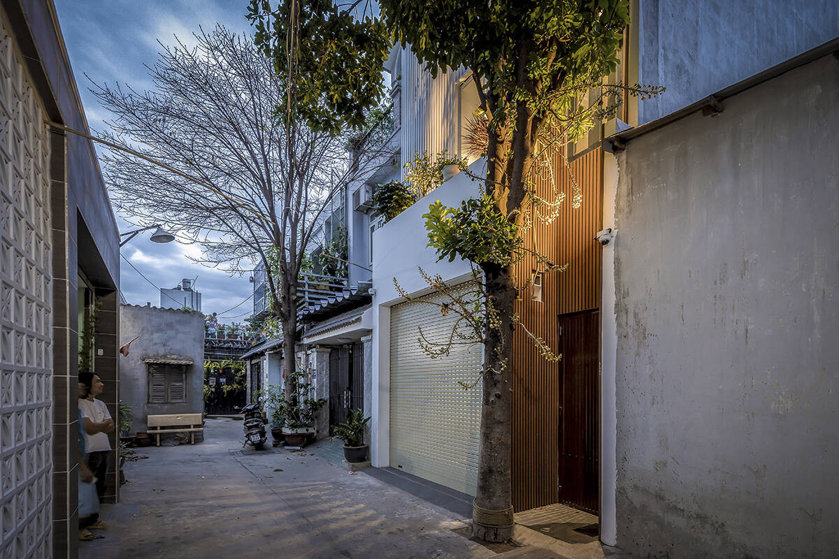 Đây là tổ ấm của gia đình 3 thành viên gồm vợ chồng và cô con gái nhỏ. Ngay trước nhà có cây sala lớn. Nhóm thiết kế đã tư vấn giữ lại cây vừa lưu giữ kỷ niệm, vừa tận dụng làm “tấm khiên” cản nắng hướng Tây cho nhà.