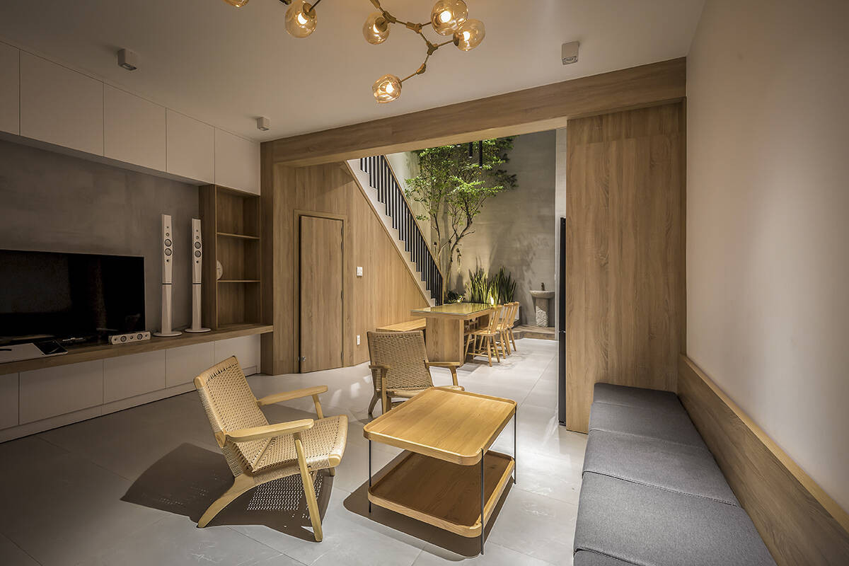 Phòng khách sử dụng nội thất đơn giản để tạo cảm giác rộng rãi. Ghế sofa văng dài ốp tường, tạo cảm giác gọn gàng.