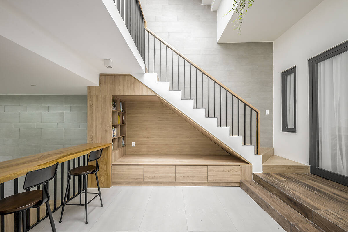 Một góc thư giãn được bố trí hướng ra khoảng thông tầng để gia chủ nghỉ ngơi. Gầm cầu thang được tận dụng thành góc đọc sách. Những chậu cây được đặt ở tầng lửng, thoả mãn tình yêu chăm sóc cây cảnh của gia chủ.