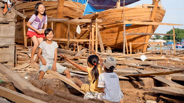 Những đứa trẻ ở thôn Cổ Lũy, xã Nghĩa Phú, huyện Tư Nghĩa (Quảng Ngãi) chơi trò bập bênh bằng những tấm ván đóng tàu đánh cá - Ảnh: Tiến Thành