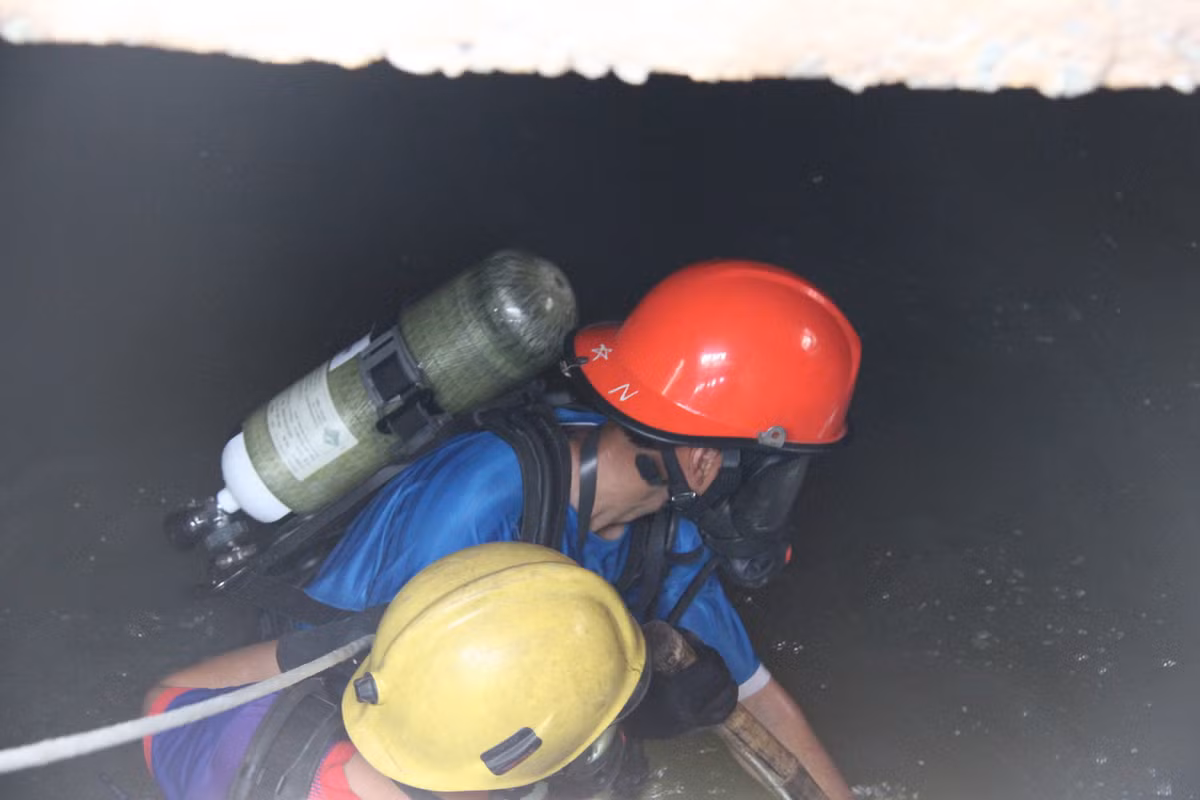 Công việc tìm kiếm nạn nhân dưới ống cống rất khó khăn do đường ống ăn thông với nhau. Ảnh: Bá Sơn.