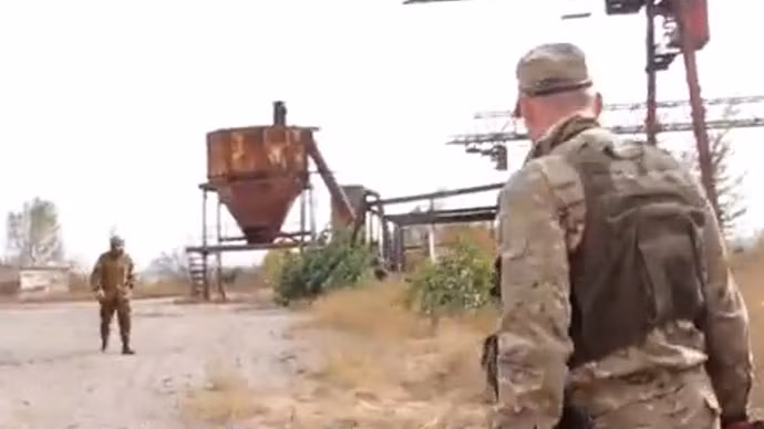 Dân quân tự vệ tới khu vực phát hiện hố chôn tập thể. Ảnh cắt từ ra đoạn clip đăng tải trên RT.