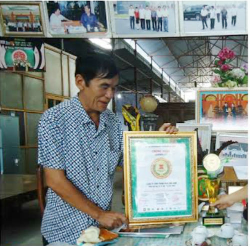 Nguyễn Thành Hưng bên Bằng khen "Nhân tố mới thời đại Hồ Chí Minh” của Ban Tuyên giáo trung ương.