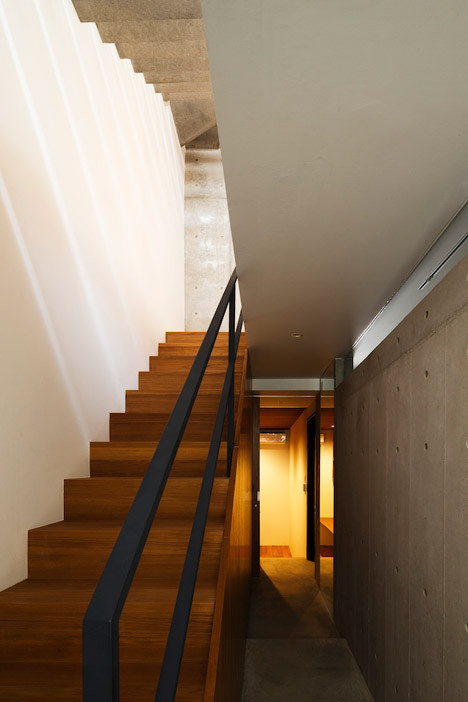 Một phòng ngủ và phòng tối chụp ảnh nằm trên cầu thang, cách khu vực bên dưới là 1 nhà bếp và khu vực ăn uống ở phía sau và phòng khách ở phía trước.