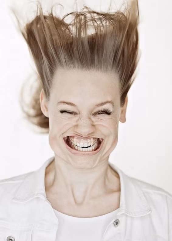 Có lẽ người phụ nữ này đang cố cười thật tươi nhưng cô không nghĩ rằng lực của gió lại khiến nụ cười của cô trở nên méo mó.