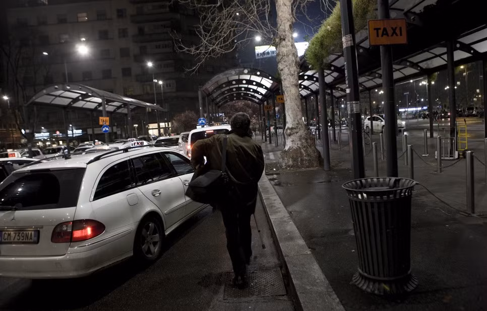 Ông bắt taxi bên ngoài nhà ga Milano.