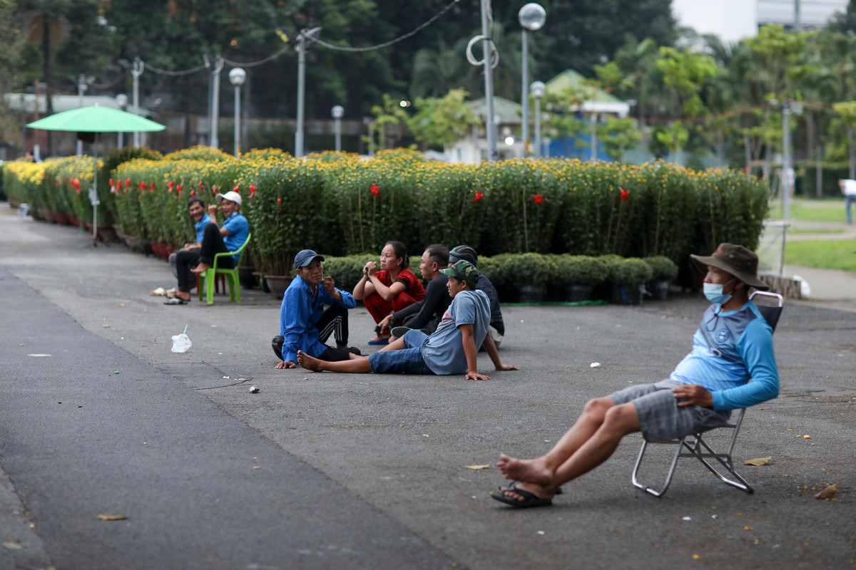 Không có khách hỏi mua do lượng hoa nhập về ít, nhiều tiểu thương tại chợ hoa này chủ yếu lướt điện thoại, tụ tập, tán gẫu để giết thời gian.