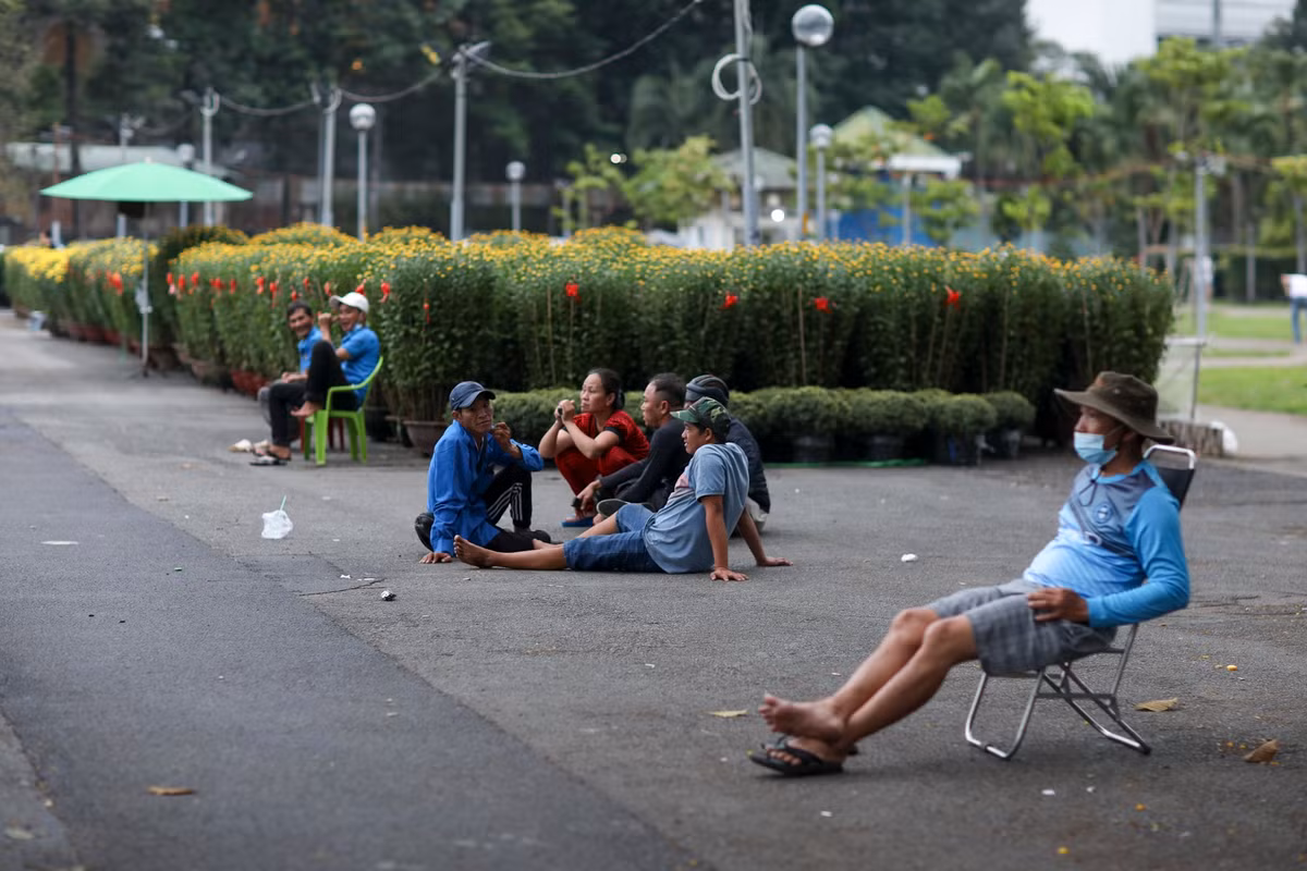 Không có khách hỏi mua do lượng hoa nhập về ít, nhiều tiểu thương tại chợ hoa này chủ yếu lướt điện thoại, tụ tập, tán gẫu để giết thời gian.
