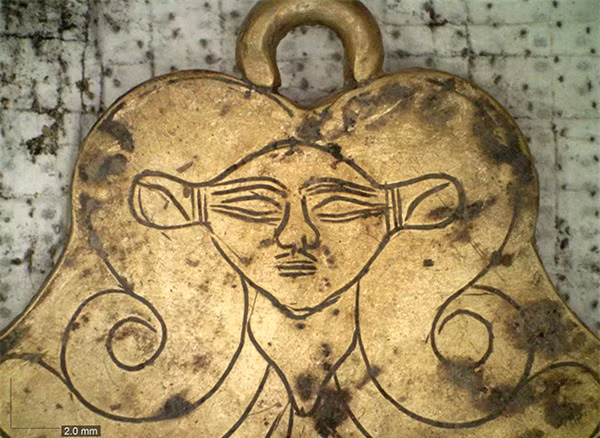 Mặt dây chuyền bằng vàng chạm khắc khắc hình đầu của nữ thần Ai Cập cổ đại Hathor. Hai ngôi cổ mộ này được phát hiện bởi cặp vợ chồng Jack L. Davis và Sharon R. Stocker - các chuyên gia khảo cổ học tại Đại học Cincinnati, những người đã nghiên cứu địa điểm này từ năm 1992. Cũng chính họ đã phát hiện ra ngôi mộ Chiến binh Griffin chứa kho báu và nhiều đồ trang trí trong đó vào năm 2015.