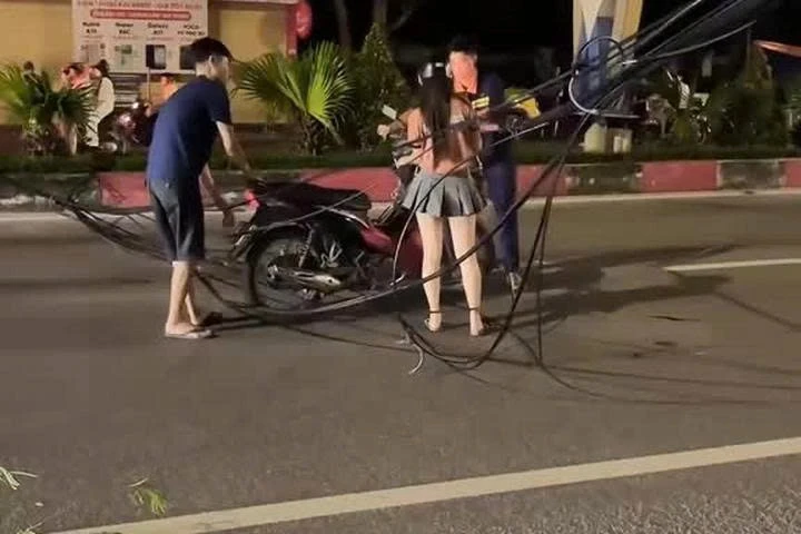 Cô gái đi xe máy vướng vào chùm dây cáp điện rơi giữa đường