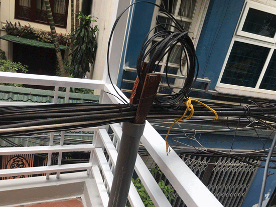 Bó cáp chạy sát ngay ban công tầng 2 nhà một hộ dân ở quận Đống Đa.