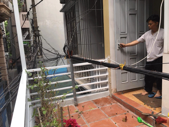 Bó dây cáp các loại chạy ngang qua ban công tầng 2 nhà anh Hoàng Văn Trường, chỉ cần mở cửa bước ra là chạm vào.