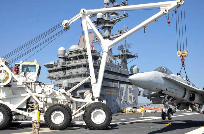Thủy thủ đang sử dụng xe cẩu để cẩu chiếc tiêm kích F/A-18 Hornet trên tàu sân bay USS Ronald Reagan (CVN-76).