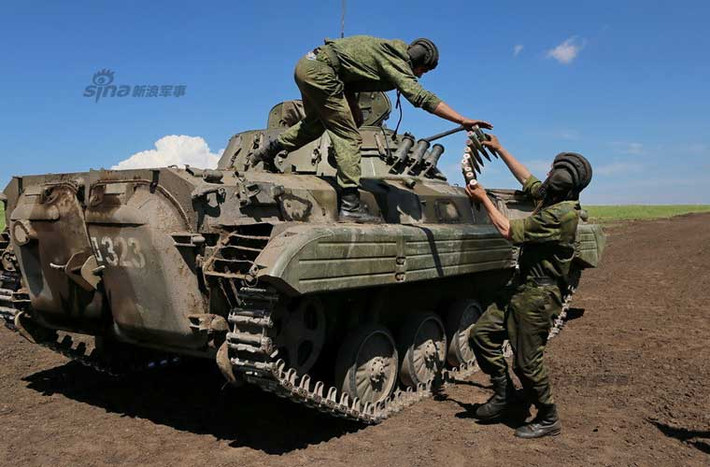 Nhằm chuẩn bị cho cuộc thi tăng quốc tế “tank biathlon 2015” sẽ diễn ra vào tháng 8, các đơn vị tăng – thiết giáp Nga đang nỗ lực huấn luyện nhằm được tham gia vào đội tuyển đại diện cho nước Nga “chiến đấu” giành chức vô địch tank biathlon. Trong ảnh, kíp lái xe chiến đấu bộ binh BMP-2 đang chuyển đạn pháo vào xe chuẩn bị cho bài tập.