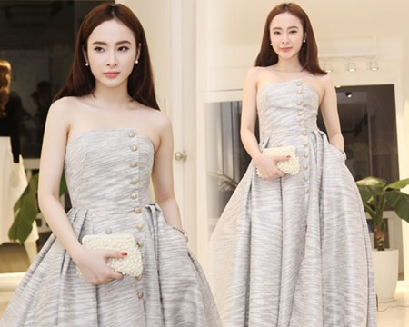 Chiếc váy được lên ý tưởng với điểm nhấn là tùng xòe ra rất tinh tế và đẹp mắt. Những cúc khóa được đính ở thân áo đều được mạ vàng để tạo sự đẳng cấp. Chất liệu kim tuyến bắt sáng với tông xanh pastel giúp Angela Phương Trinh tỏa sáng hơn trên thảm đỏ.