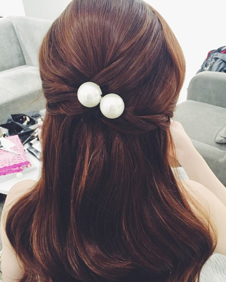 Mái tóc buộc nửa đầu được tạo điểm nhấn bằng ngọc trai.