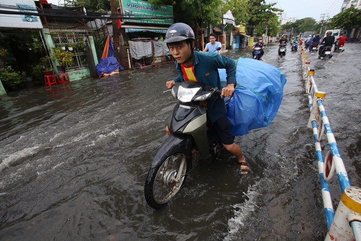 Tuy vui vì đón 'mưa vàng' giải nhiệt nhưng đường ngập khiến việc đi lại của người dân gặp khó khăn