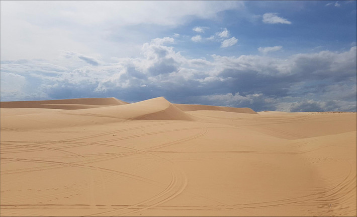 Được ví như tiểu sa mạc Sahara, đồi cát Bàu Trắng là điểm du lịch độc đáo không thể bỏ qua ở Bình Thuận. Nơi đây còn có tên là đồi cát bay bởi hình dáng thay đổi liên tục theo từng ngày từng giờ. Những đụn cát chập chùng trải dài mênh mông, ngút ngàn, sẽ khiến du khách bị choáng ngợp trước thiên nhiên kỳ diệu. Ảnh: Thành Em.