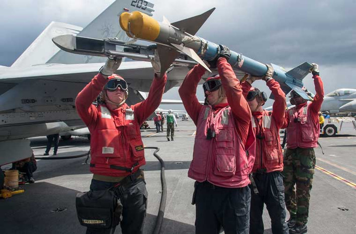 Cần bốn người đàn ông lực lưỡng mới lắp được quả đạn tên lửa AIM-9 lên cánh tiêm kích hạm F/A-18E trên tàu sân bay USS George Washington (CVN 73) hoạt động ở biển Philippine.