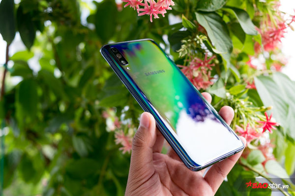Samsung Galaxy A70 được bán tại Việt Nam với đầy đủ ba phiên bản màu máy khác nhau là đen, xanh dương và trắng. Phiên bản bạn đang nhìn thấy là phiên bản màu đen. Tuy nhiên, nhờ cách thiết kế chất liệu mặt lưng mà Samsung gọi là “3D Graffitistic,” mặt lưng Samsung Galaxy A70 có thể đổi màu tuỳ theo góc nhìn và điều kiện ánh sáng khác nhau. Mặt lưng máy cũng được thiết kế bo cong để giảm cảm giác cấn tay cho người dùng khi tương tác với thiết bị trong một thời gian dài.