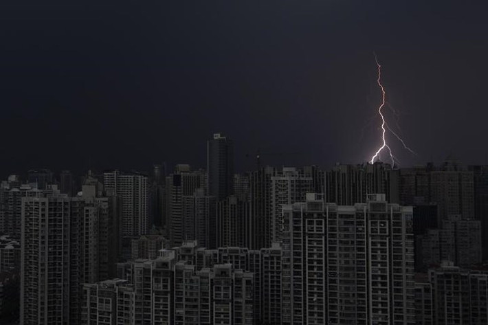 Tia chớp xé toạc bầu trời tối đen trên những tòa nhà chọc trời ở Thượng Hải (Trung Quốc) ngày 15/8/2012.