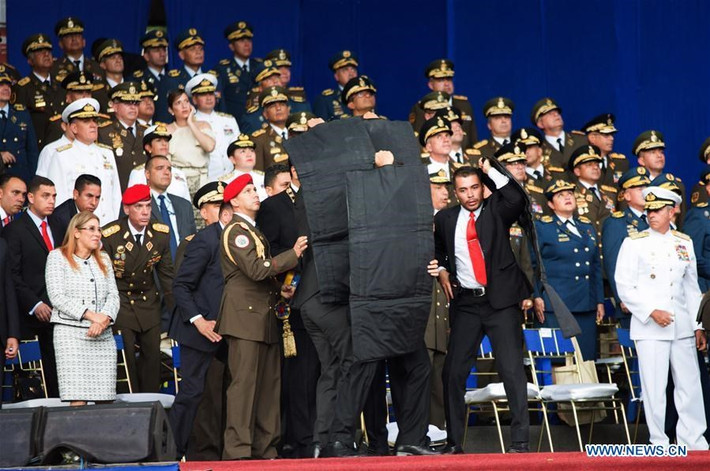 Những hình ảnh sau đó cho thấy các vệ sỹ che chắn cho ông Maduro với những tấm chống đạn màu đen. Nguồn ảnh: news.cn