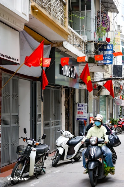 Không chỉ trên các con phố lớn mà những lá cờ rủ còn len lỏi vào nhưng ngõ ngách. Người dân đã treo cờ rủ tại một con ngõ trên phố Tây Sơn (quận Đống Đa). (Ảnh: Minh Hiếu/vietnam+)