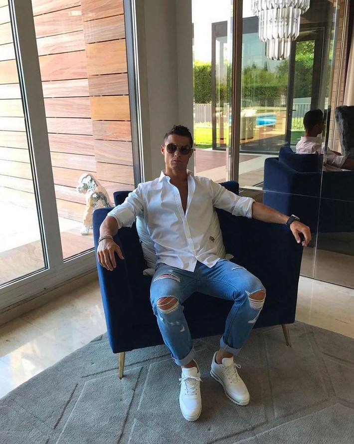 Ronaldo lạnh lùng ngồi trên ghế sofa.