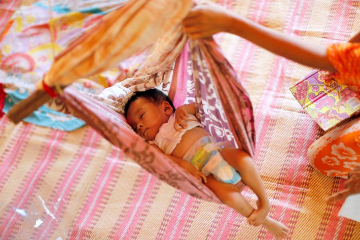 Em bé sơ sinh ngủ trên võng trong trại tị nạn. Ảnh: REUTERS