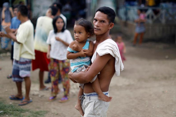 Một người tị nạn bế con trong trại tị nạn ở thành phố Iligan. Ảnh: REUTERS
