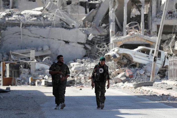 Các chiến binh của Lực lượng Dân chủ Syria đi dọc chiến tuyến ở thành phố Raqqa. Ảnh: REUTERS