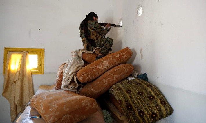 Một chiến binh của Lực lượng Dân chủ Syria chiếm vị trí chiến đấu trong nhà ở Raqqa. Ảnh: REUTERS