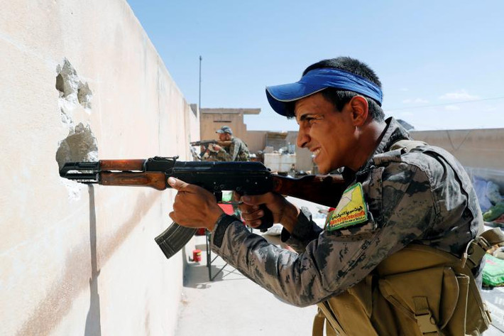 Các thành viên của Lực lượng Dân chủ Syria chiếm vị trí trên sân thượng trong một trận chiến với phiến quân IS ở Raqqa. Ảnh: REUTERS