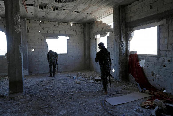 Các thành viên của Lực lượng Dân chủ Syria chiếm các vị trí trong nhà khi chiến đấu với các tay súng khủng bố của Nhà nước Hồi giáo trong thành phố Raqqa. Ảnh: REUTERS