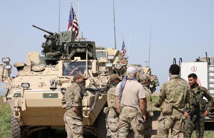 Một nhóm lính Mỹ đứng gần một xe quân sự ở phía bắc Raqqa, tháng 11/2016. Ảnh: REUTERS