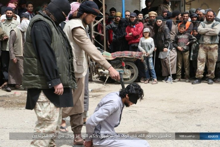 Phiến quân IS đã áp dụng luật Hồi giáo Sharia, một bộ luật hình sự tôn giáo khắc nghiệt, đối với thường dân sống ở khu vực phía đông tỉnh Deir Ezzor. Trong ảnh: Phiến quân IS hành quyết công khai một tù nhân trước đám đông, trong đó có nhiều trẻ em. Ảnh: Al Masdar News