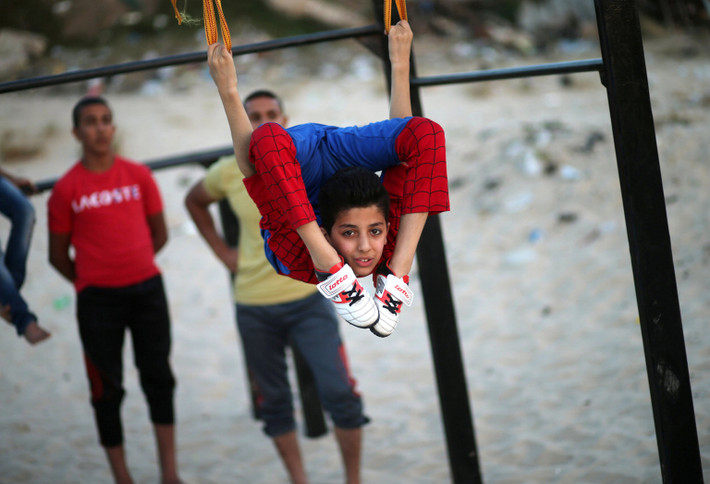 "Người nhện" Mohamad al-Sheikh biểu diễn trên bãi biển ở thành phố Gaza. Ảnh: Reuters