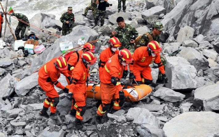 Lực lượng cứu hộ chuyển một thi thể khỏi hiện trường thiên tai. Ảnh: Reuters.