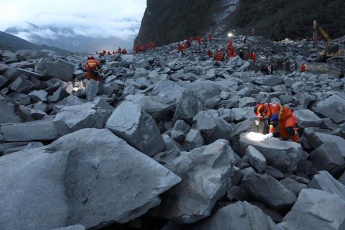 Soi đèn để tìm người gặp nạn. Ảnh: Reuters.